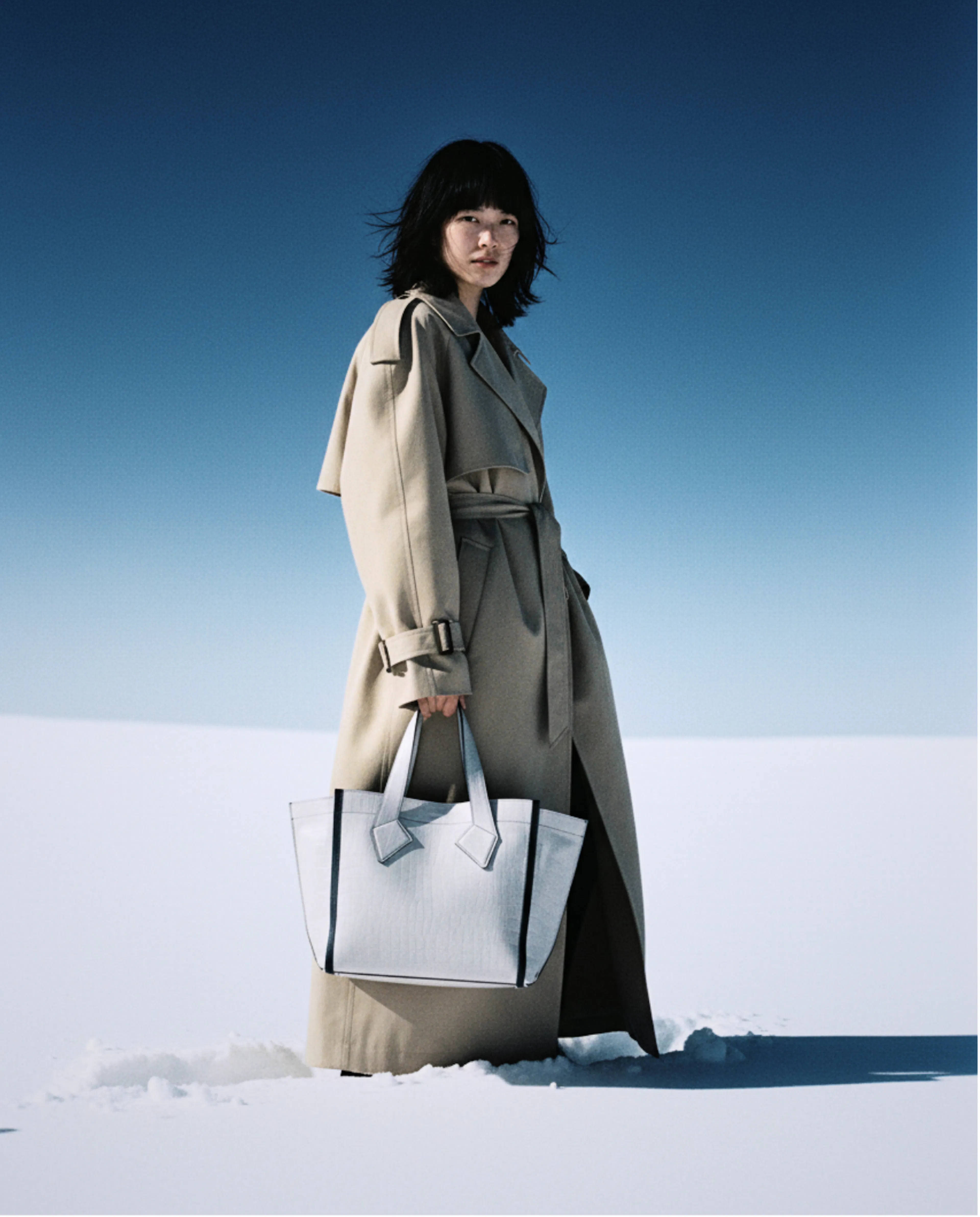 femme dans la neige avec sac à main