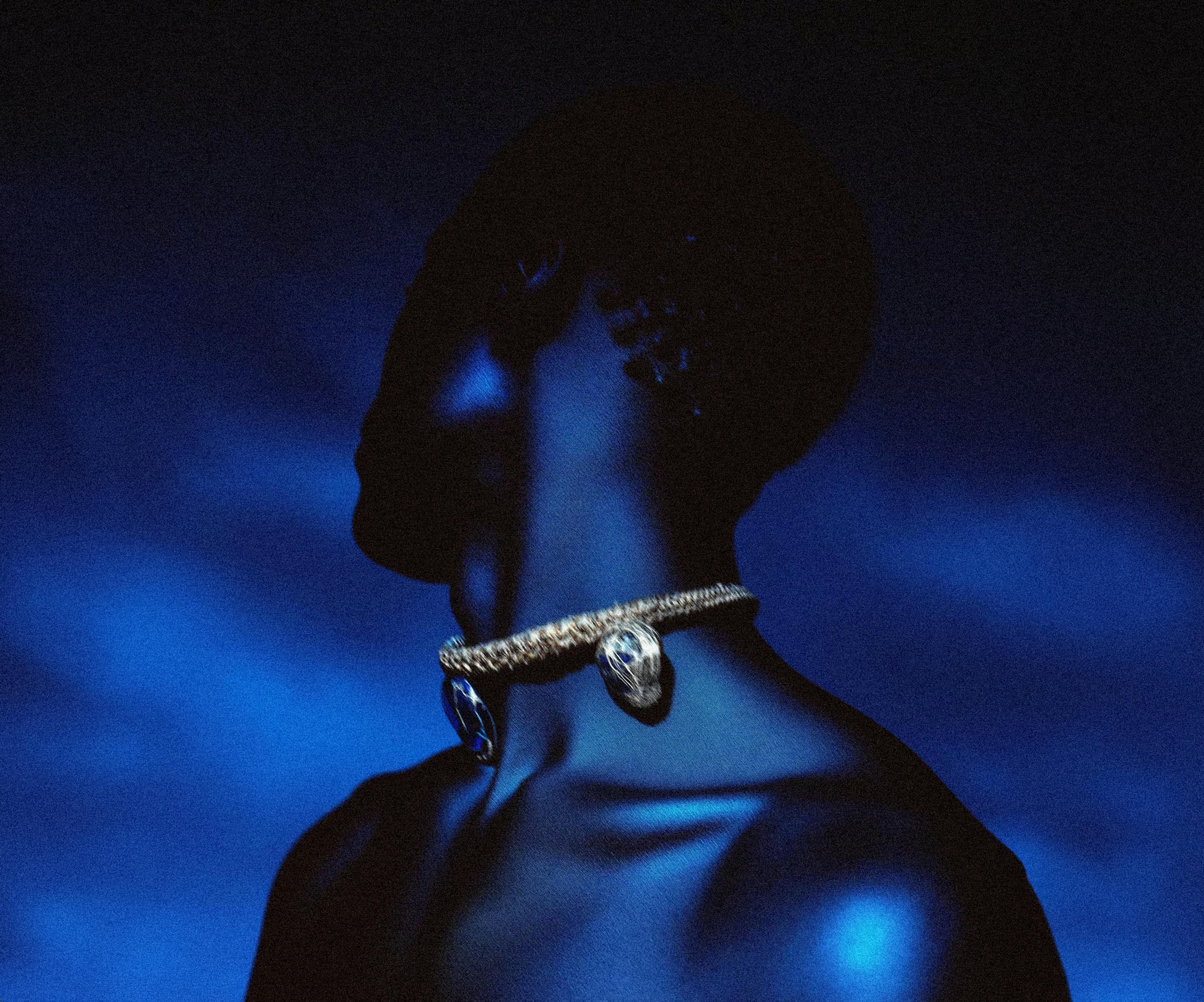 Deep blue man wearing a gold necklace