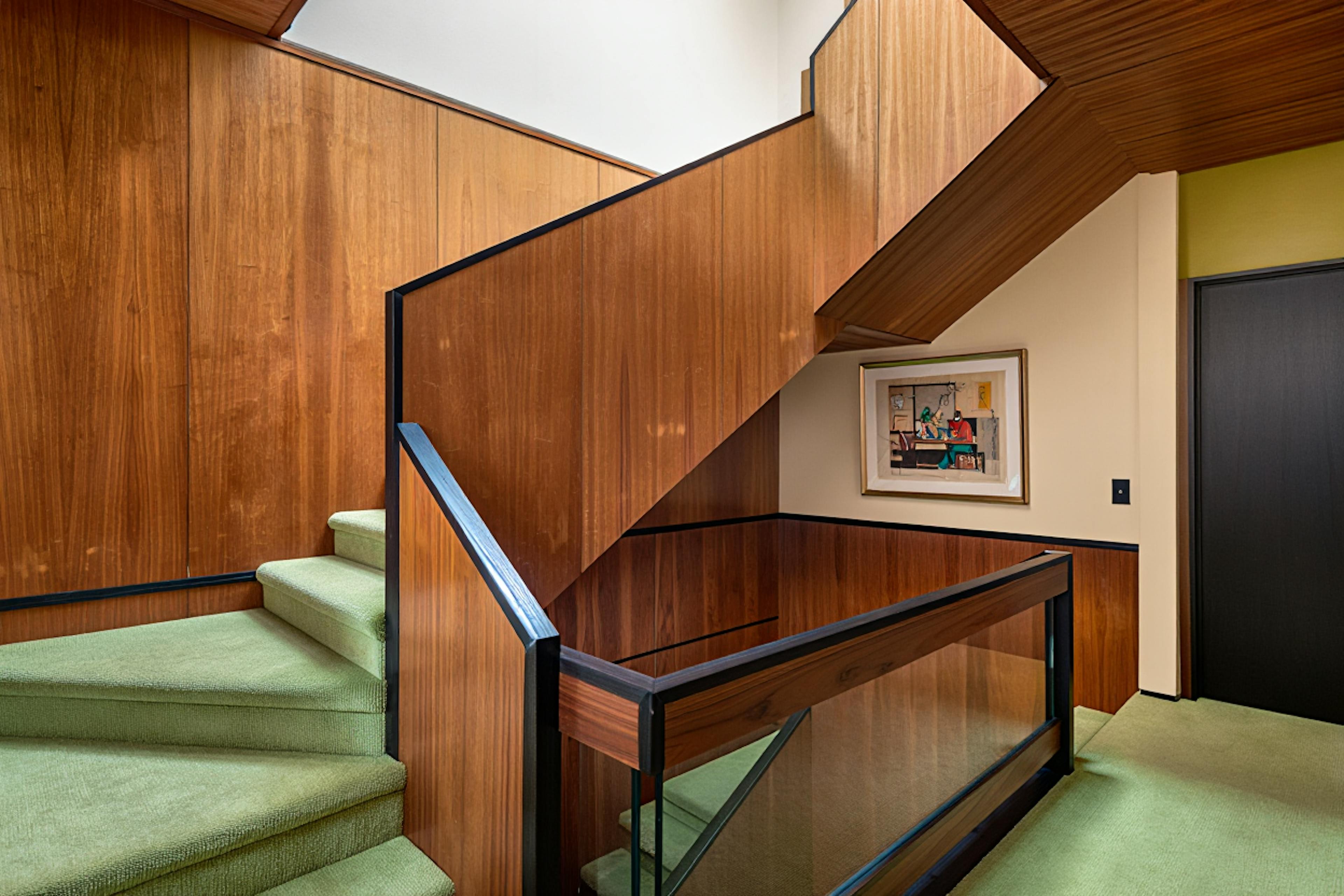 stairs with wood and green carpet on the floor