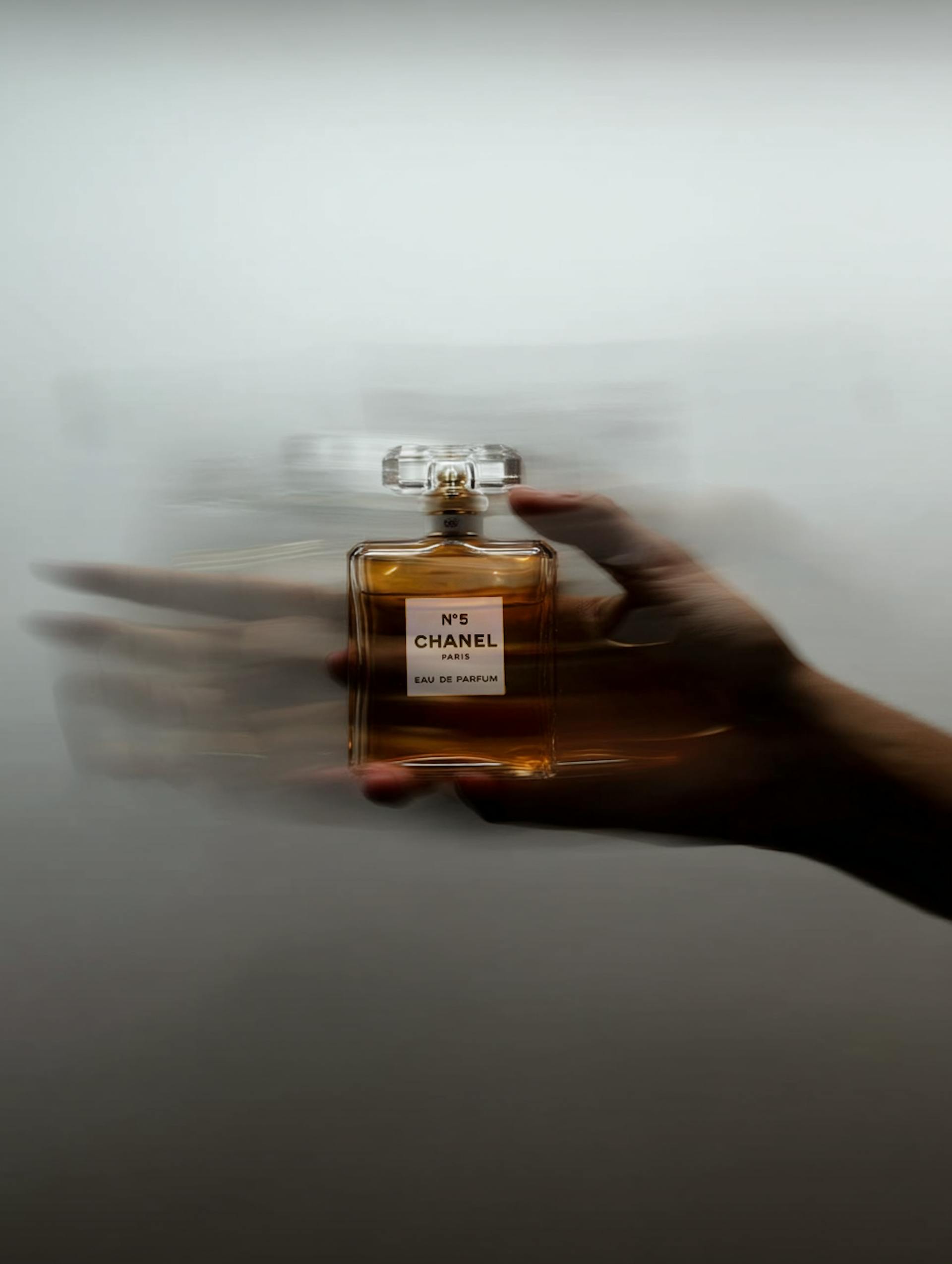 hand holding a chanel perfume bottle