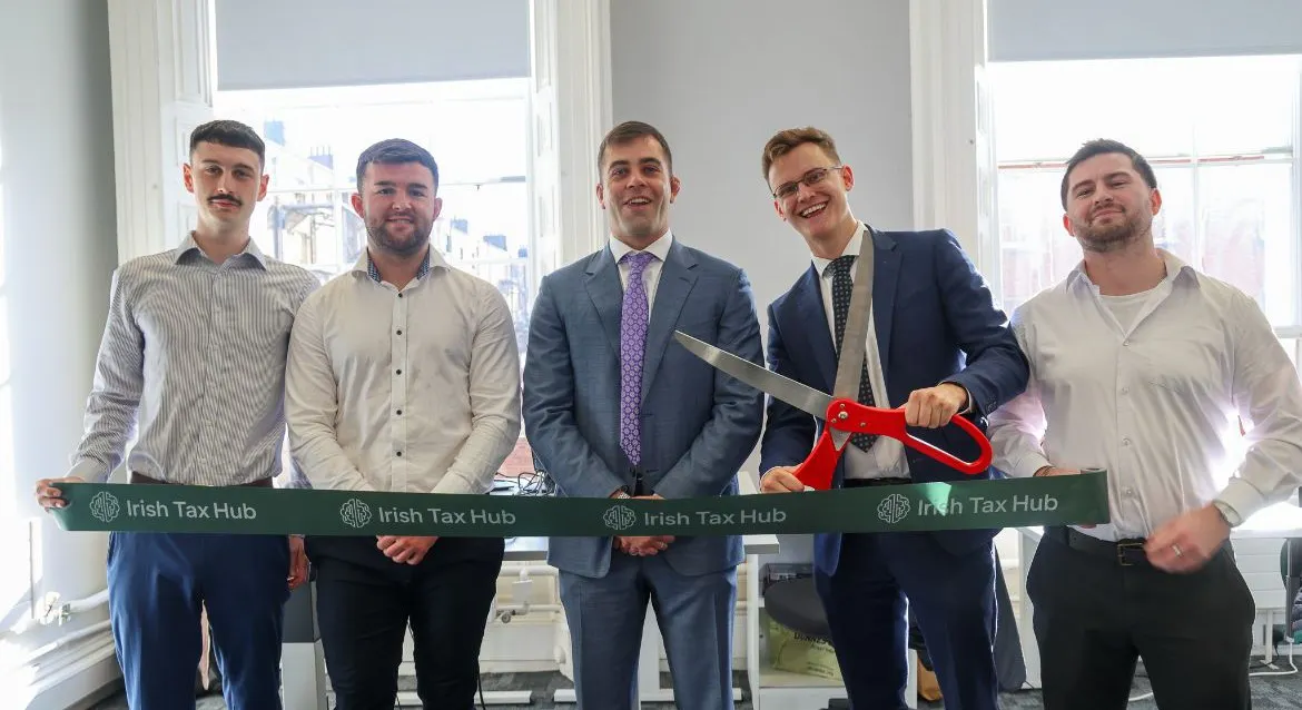 Albert Dolan TD cutting the ribbon with Damien Roche and the Irish Tax Hub team at the official opening of the new office