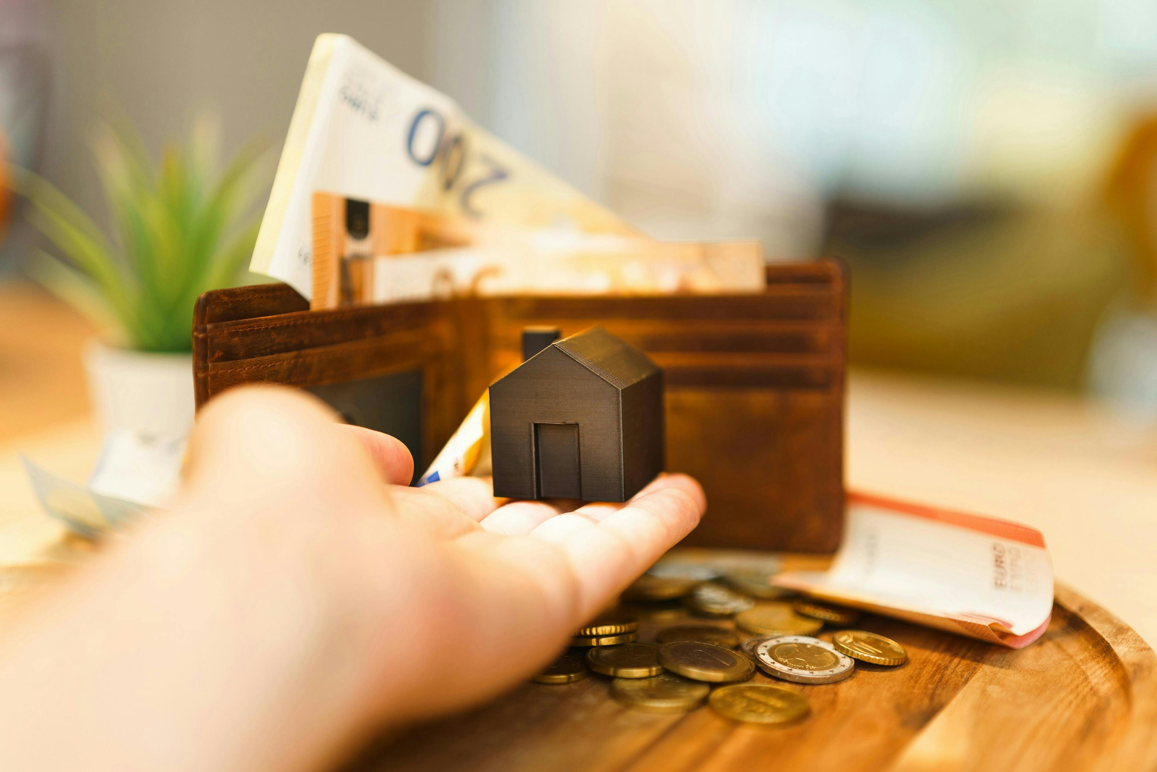 A hand holding a mini house
