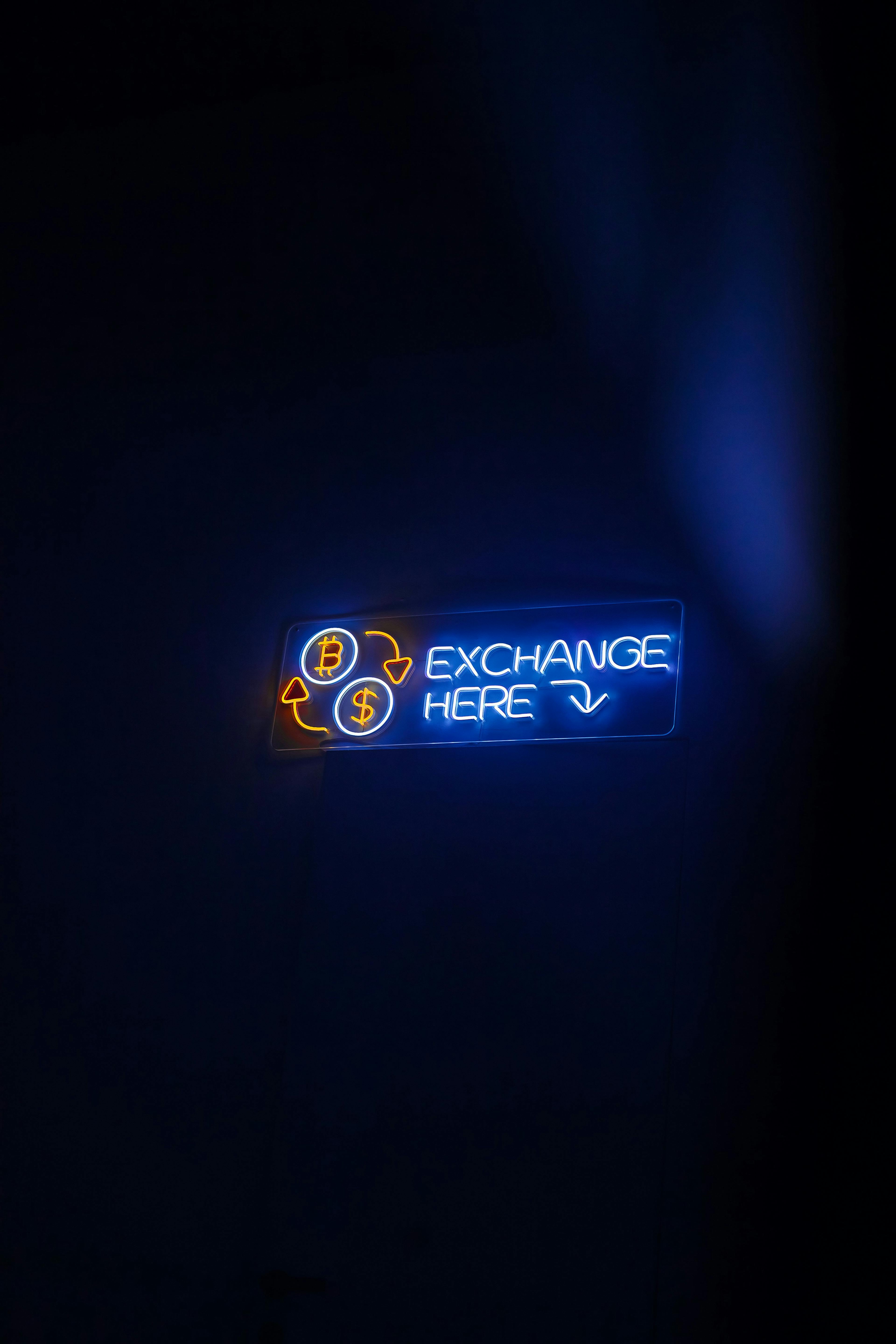 Neon sign reading “Exchange here”