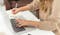 author typing at a computer and writing on a notebook, making the research process easier