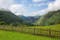 green mountains behind a wooden fence