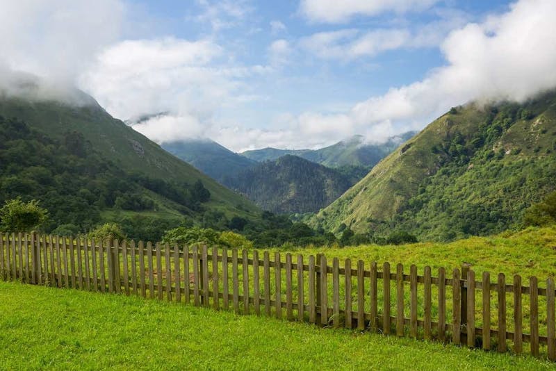 green mountains behind a wooden fence