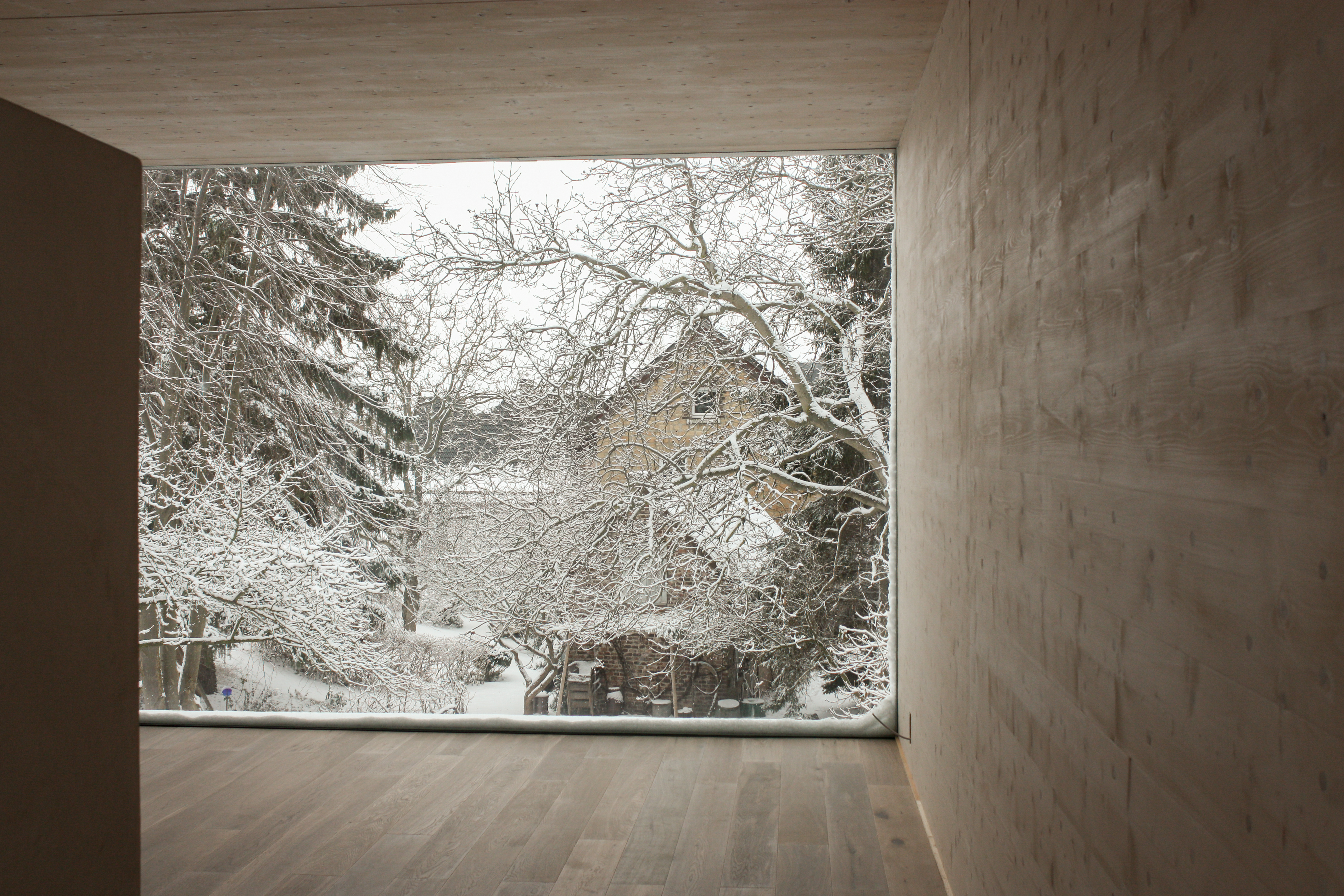 Der vollverglaste Innenraum zum Hang - Neubau eines Lofthauses in Monschau.