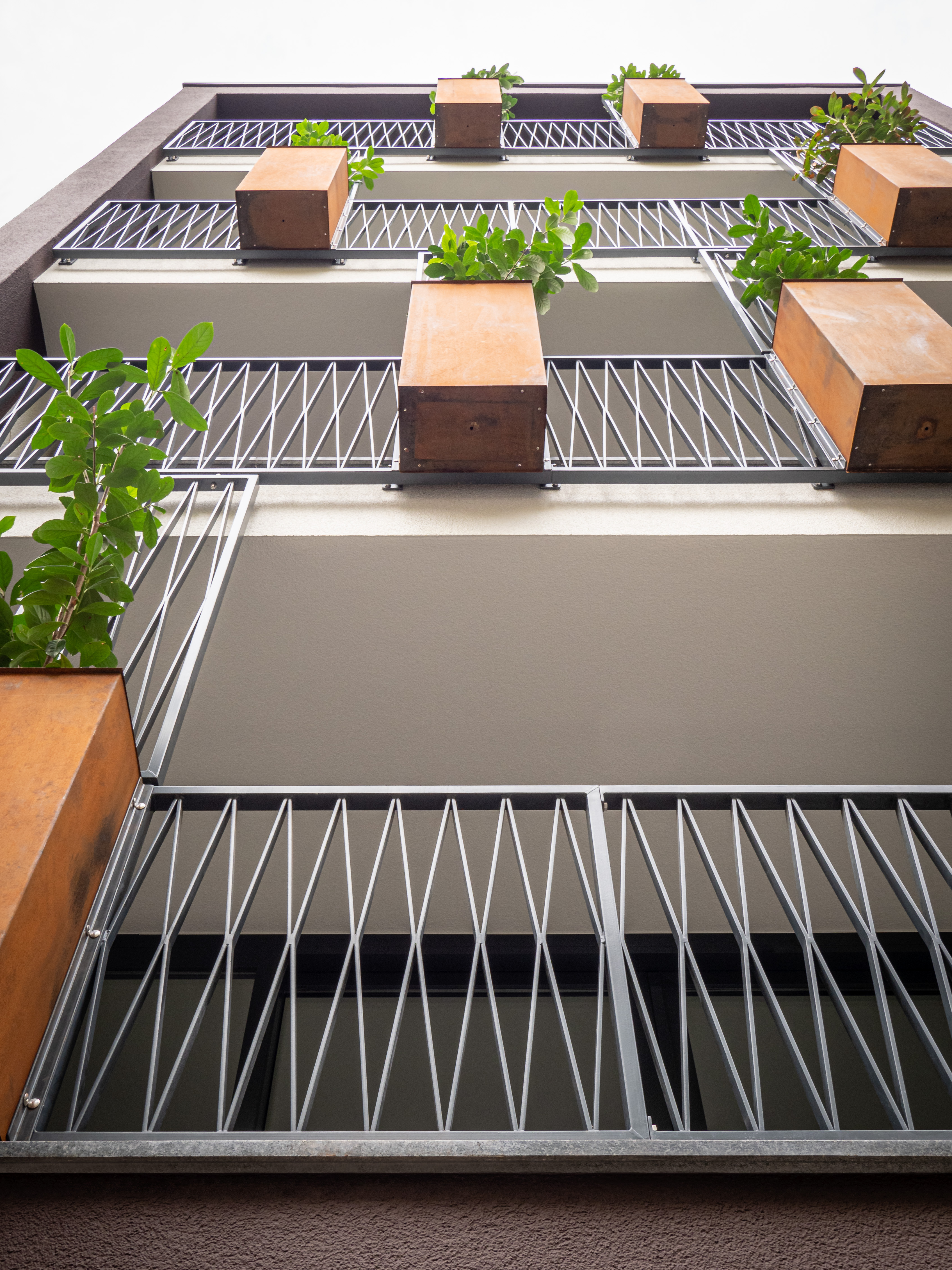 Die Pflanzenkübel aus Cortenstahl sowie Rankhilfen und Absturzsicherungen aus Gusseisen - Neubau eines Mehrfamilienhauses in Siegburg.