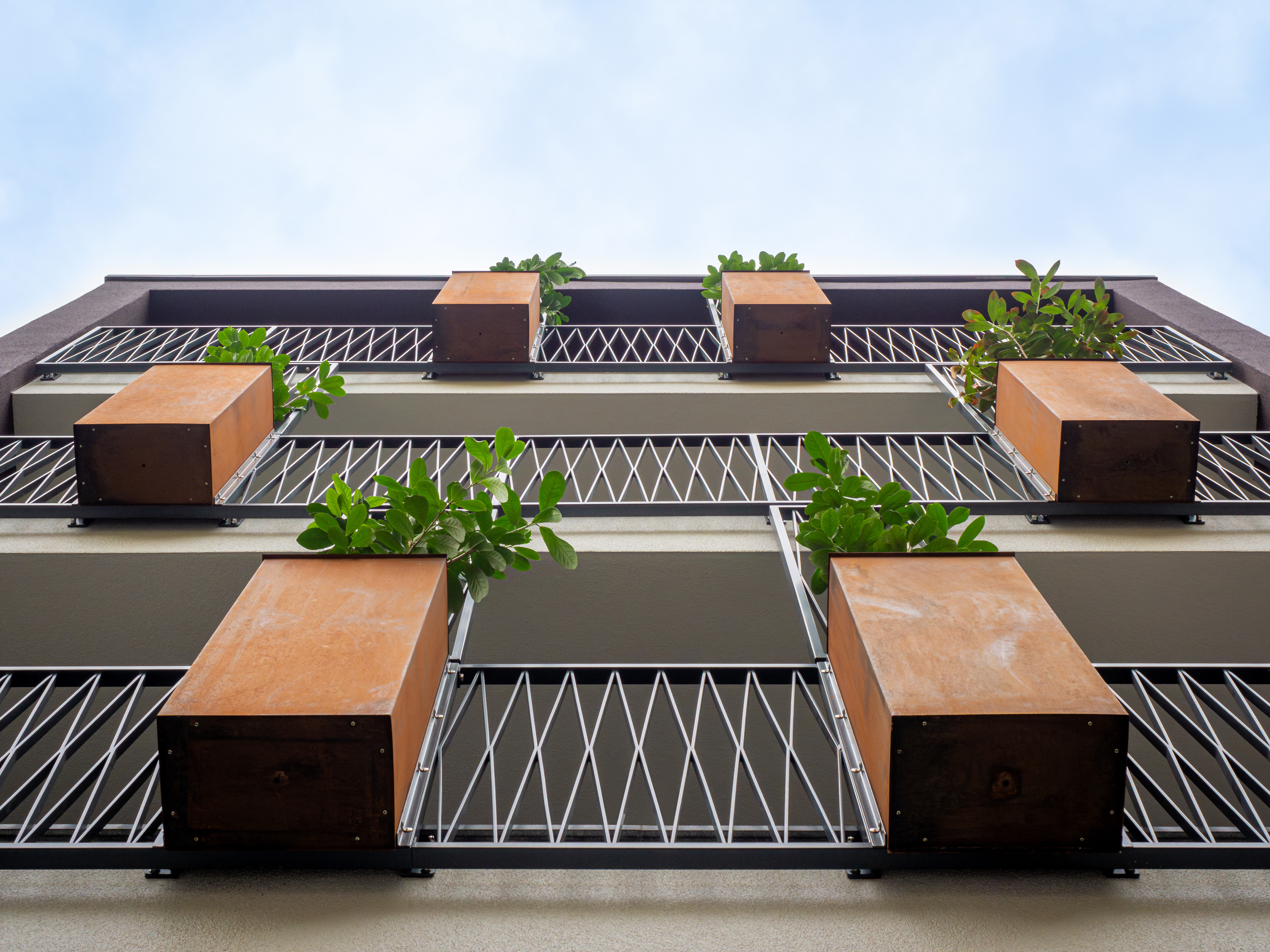 Die Pflanzenkübel aus Cortenstahl sowie Rankhilfen und Absturzsicherungen aus Gusseisen - Neubau eines Mehrfamilienhauses in Siegburg.