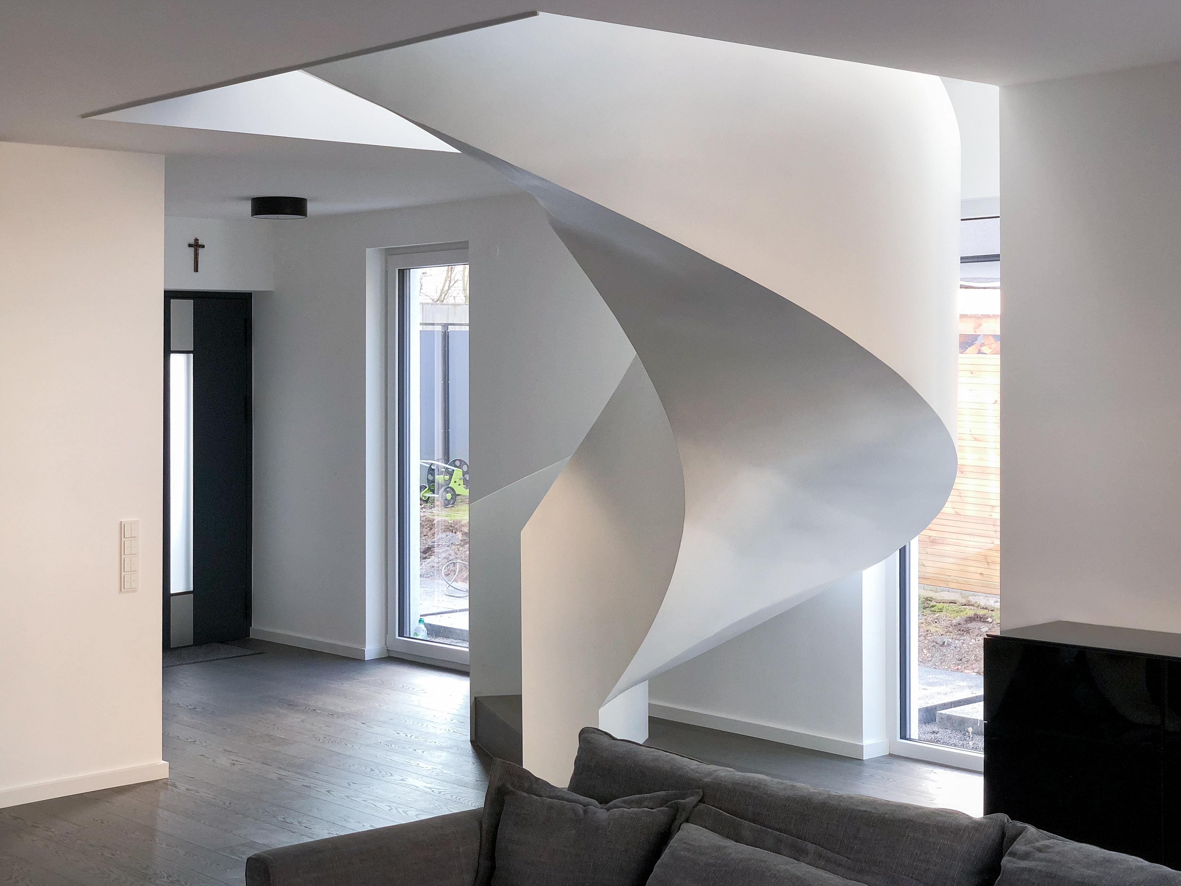 Die freistehende Wendeltreppe im Eingangsbereich - Neubau eines Einfamilienhauses mit Einliegerwohnung in Köln-Dellbrück.