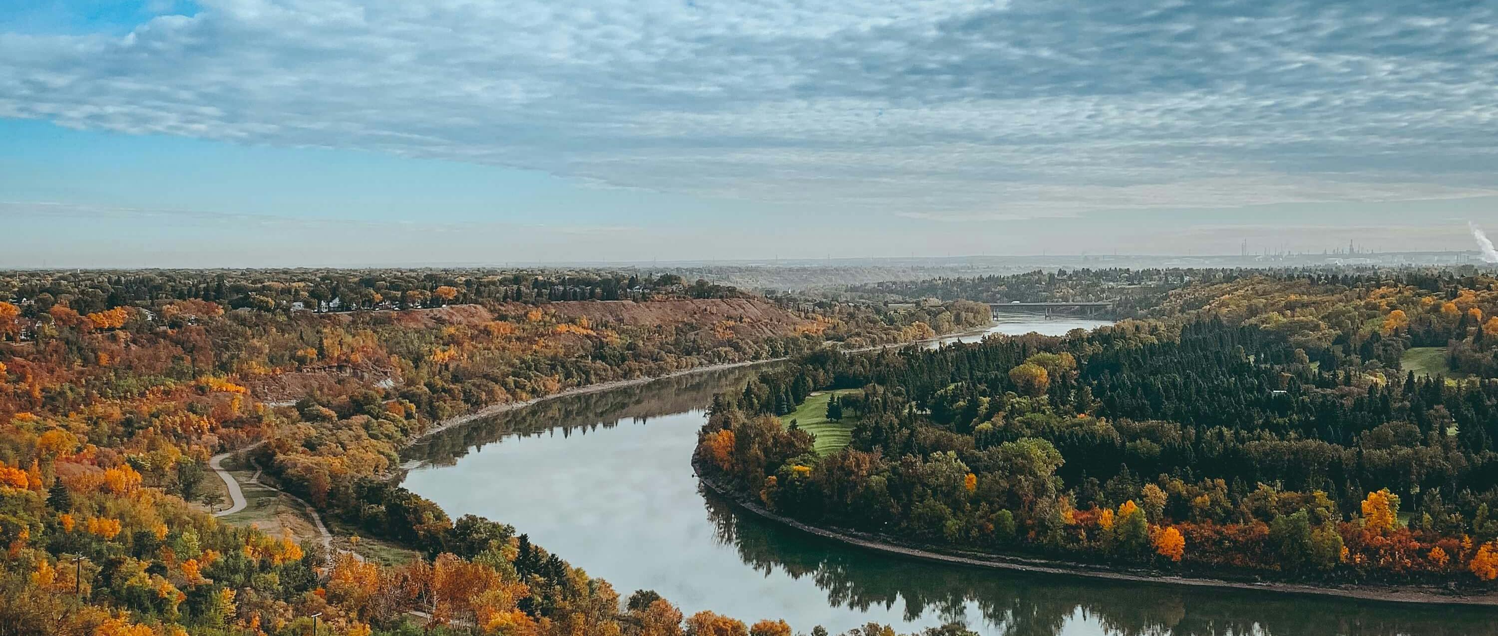 A river winding through a city during the fall.