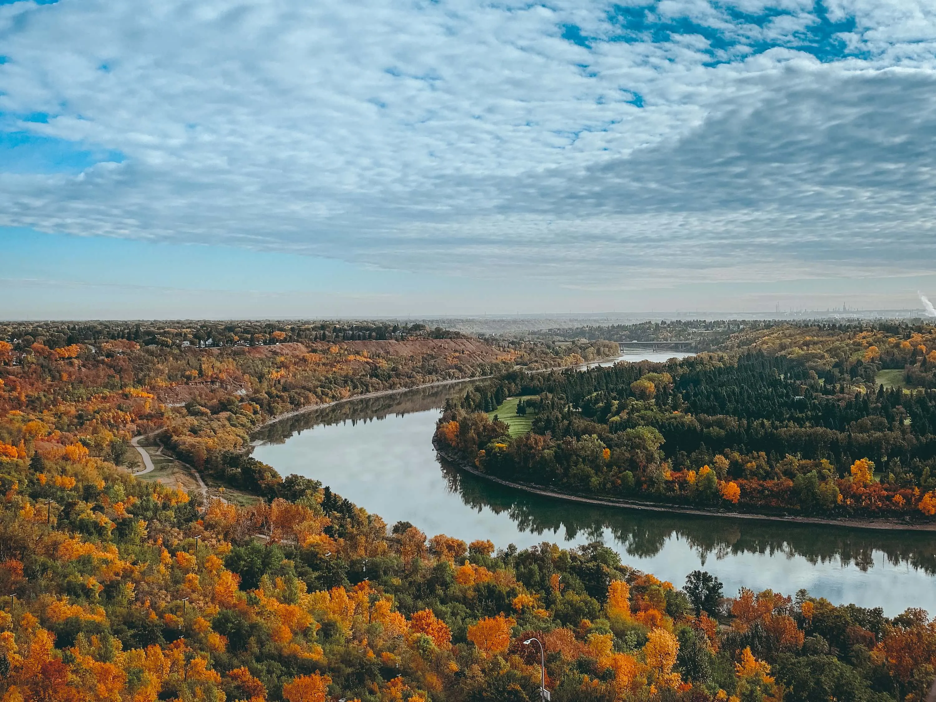 A river winding through a city during the fall.