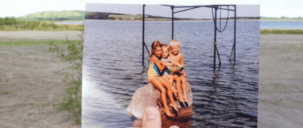 A photo of children sitting on a rock.