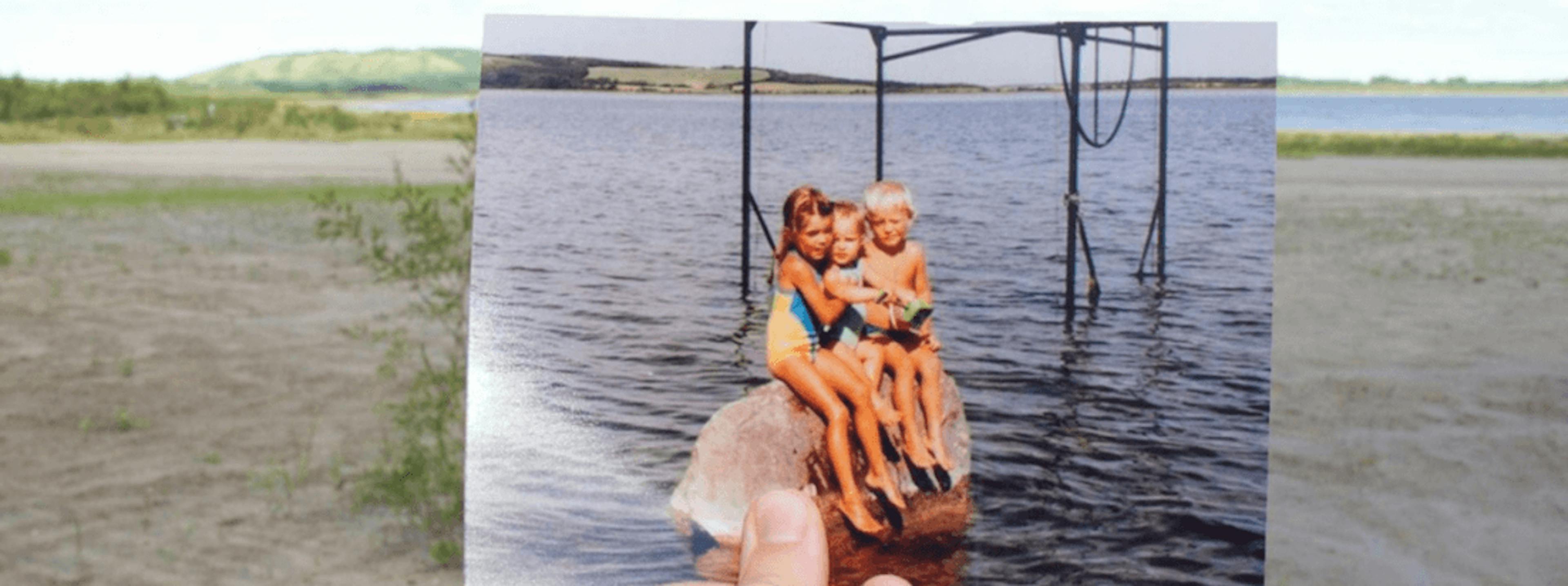 A photo of children sitting on a rock.