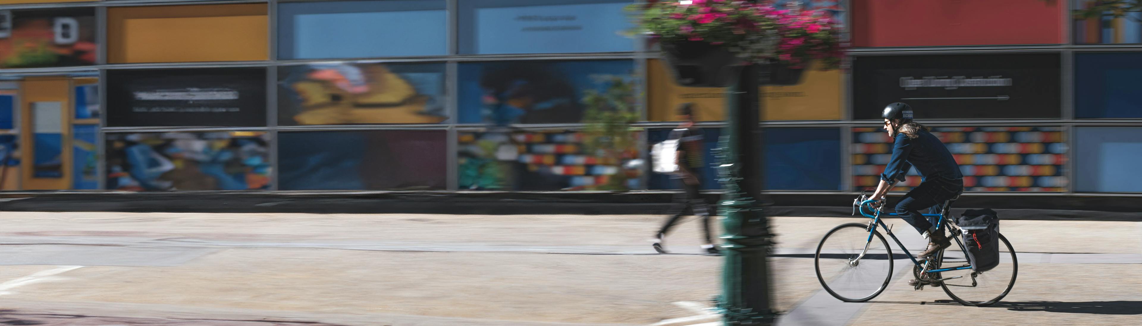 Person biking on a city sidewalk