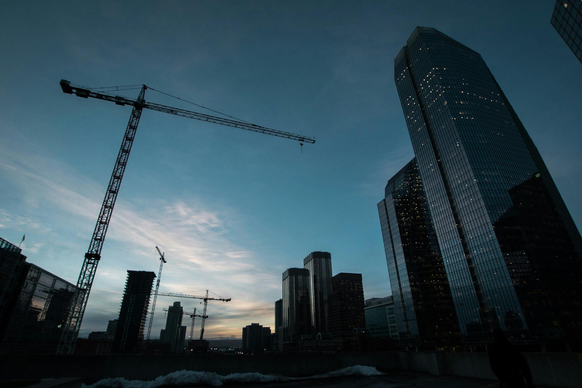 A crane and tower against a blue sky