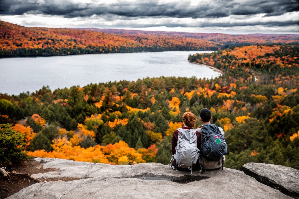 Two people sitting on a large stone at Algonquin Park