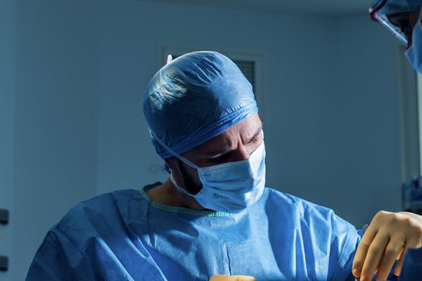Chirurgien en pleine intervention chirurgicale au bloc opératoire.
