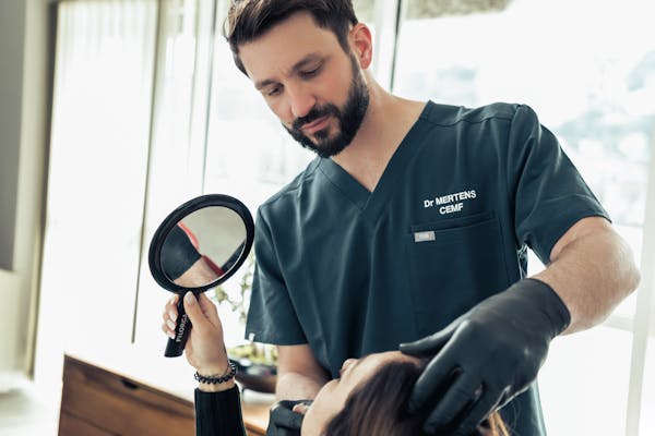 Praticien en compagnie d'une patiente dans le cadre d'une consultation pour une rhinoplastie.