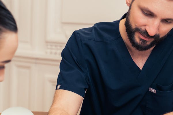 Chirurgien expert du sein en consultation avec une patiente.