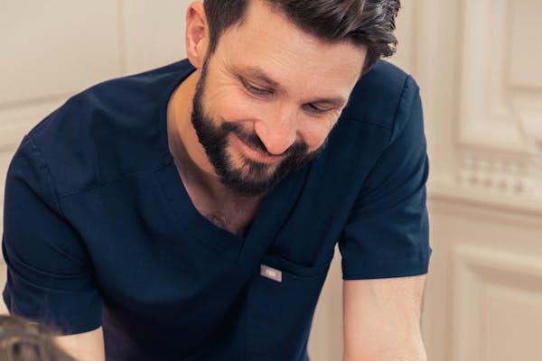 Le chirurgien expert, Alexandre Mertens, explique à l'une de ses patientes comment se déroule une rhinoplastie.