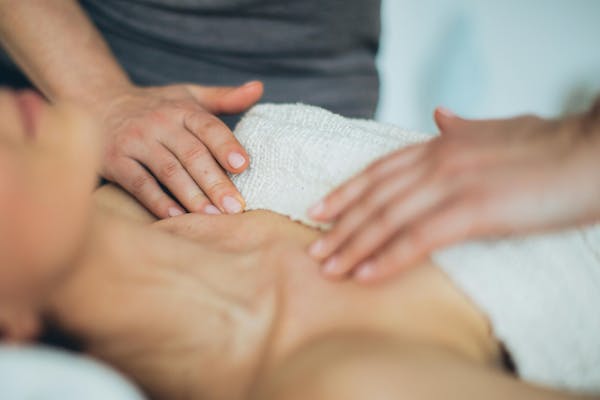 Professionnel qui réalise un massage sur une patiente.