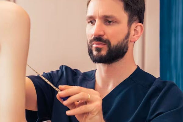 Praticien chirurgien expert du sein à Lyon en consultation avec une patiente pour augmentation mammaire.