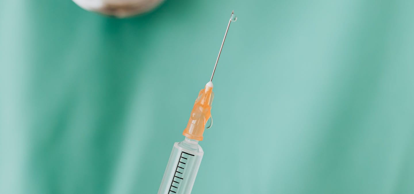 Seringue contenant de l'acide hyaluronique dans les mains d'un praticien.