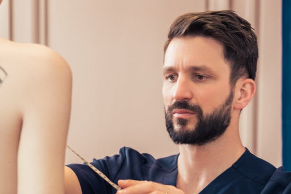 Dr. Mertens examinant une poitrine