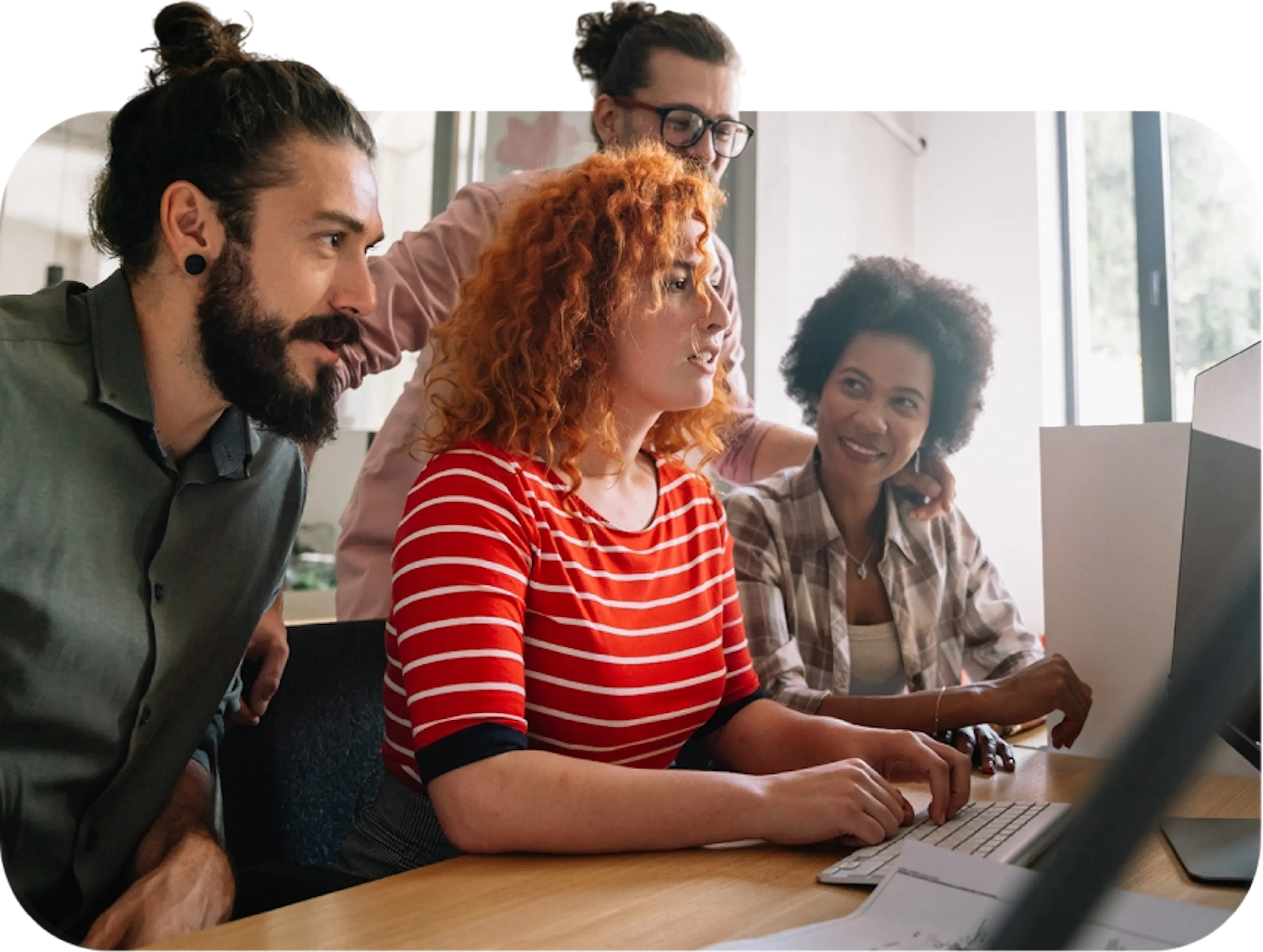 Pessoas em volts de uma mesa mexendo no computador
