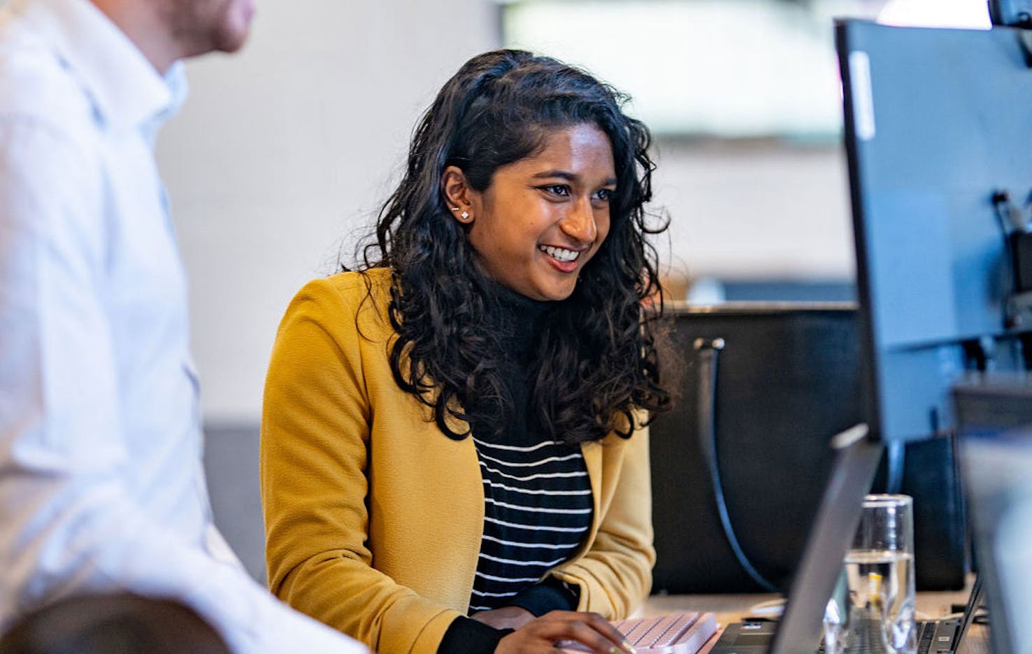 an alfa graduate smiling at work