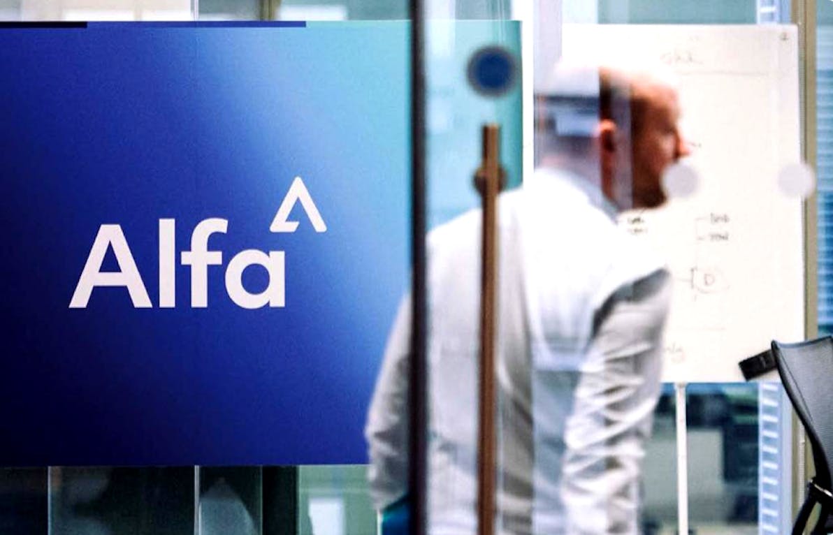 Man walking behind glass door and passing the Alfa logo