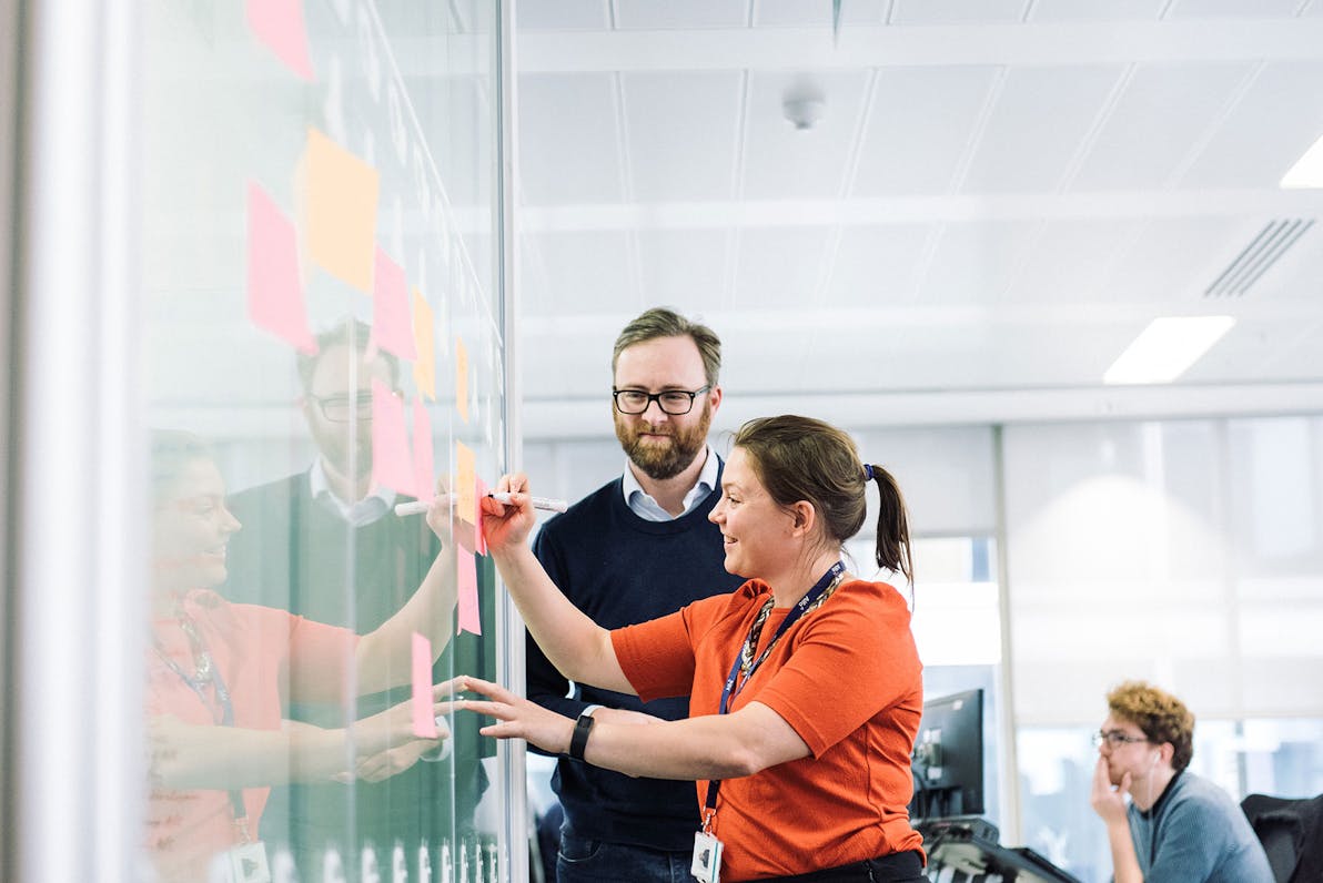 a man and a woman working at a whiteboard