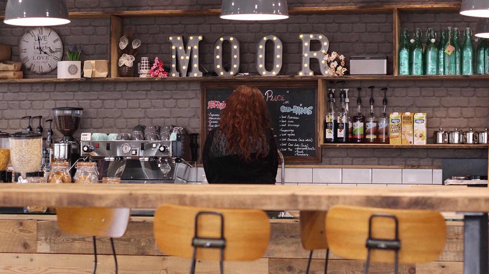 Female Employee Making Coffee in Cafe