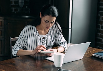 Woman working from home and using a calculator while confused about payroll tax requirements