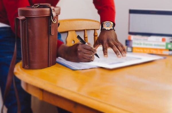 man in red sweater signing contract
