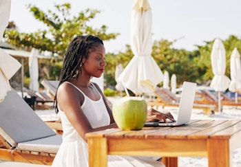 Woman working remotely from a beach destination 
