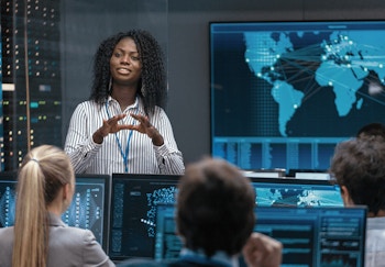 a woman speaks to her team about global cybersecurity