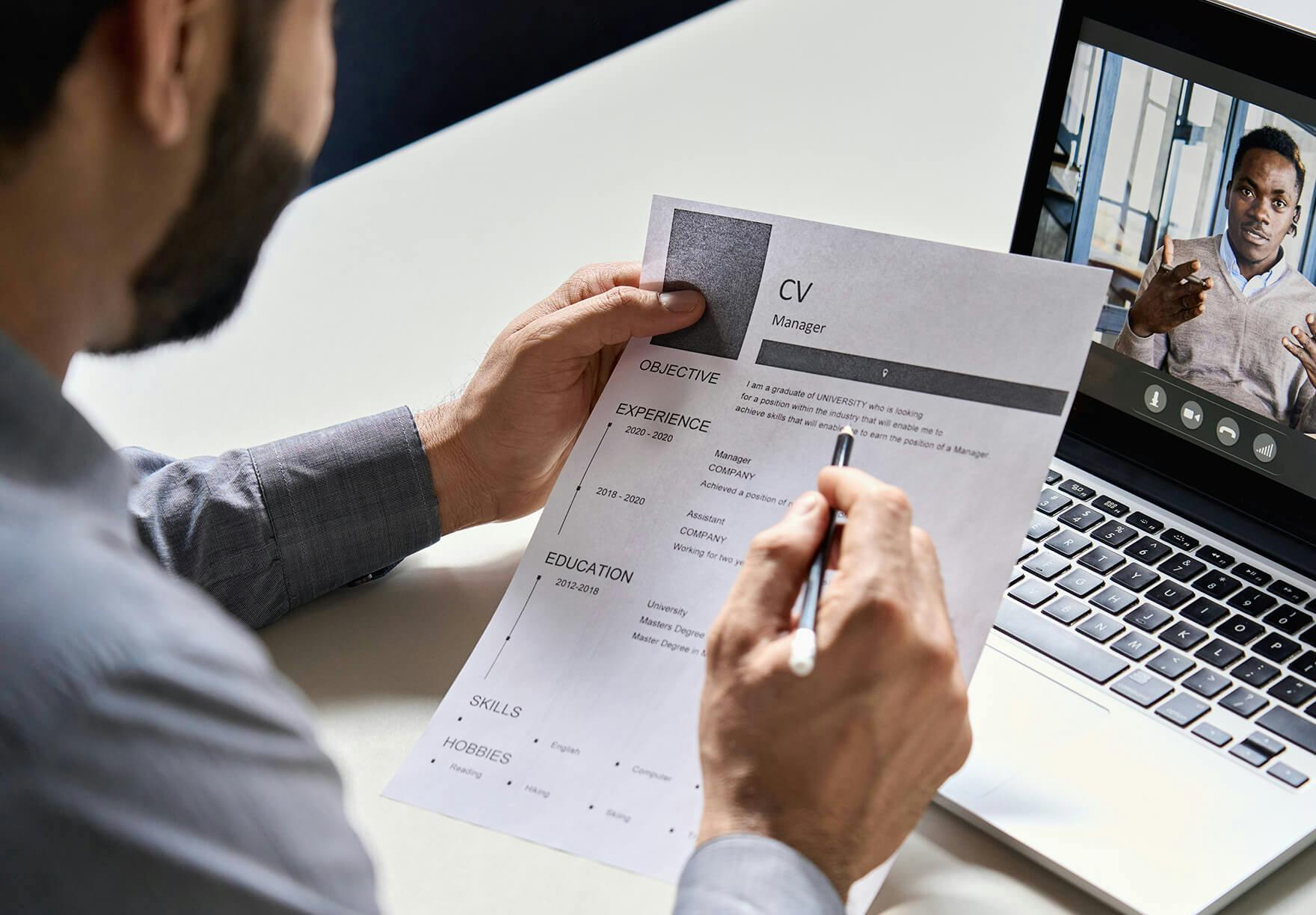 recruiter reviewing the CV of a candidate over a video call for a remote job interview