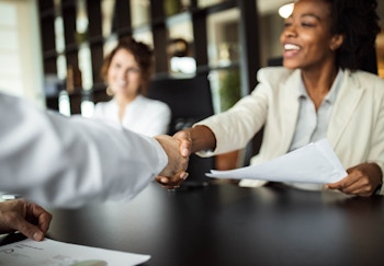People shaking hands across a table