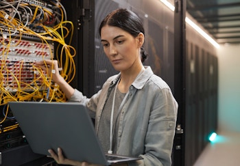 A woman with a laptop working on a server