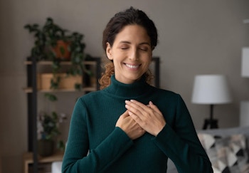 A woman practicing mindfulness with hands on heart