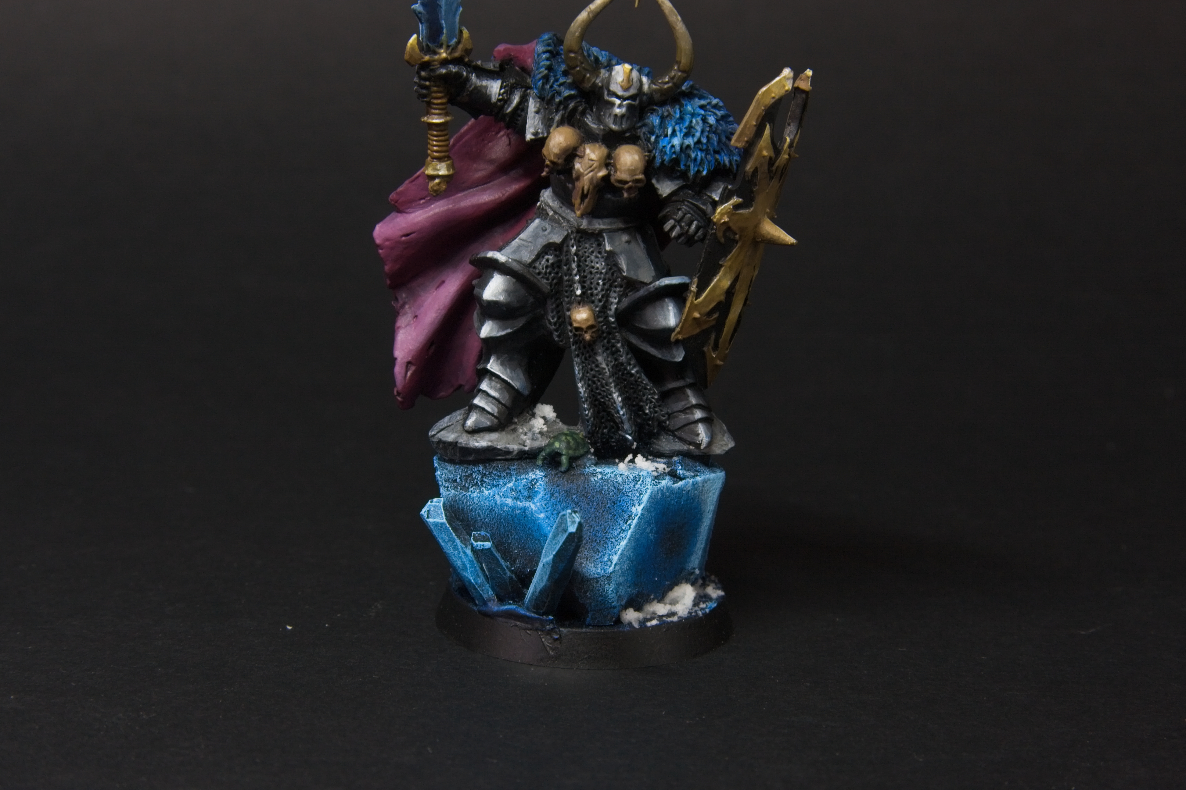 A blue and black crystal that Archon is standing on. A small turtle stands beneath him.