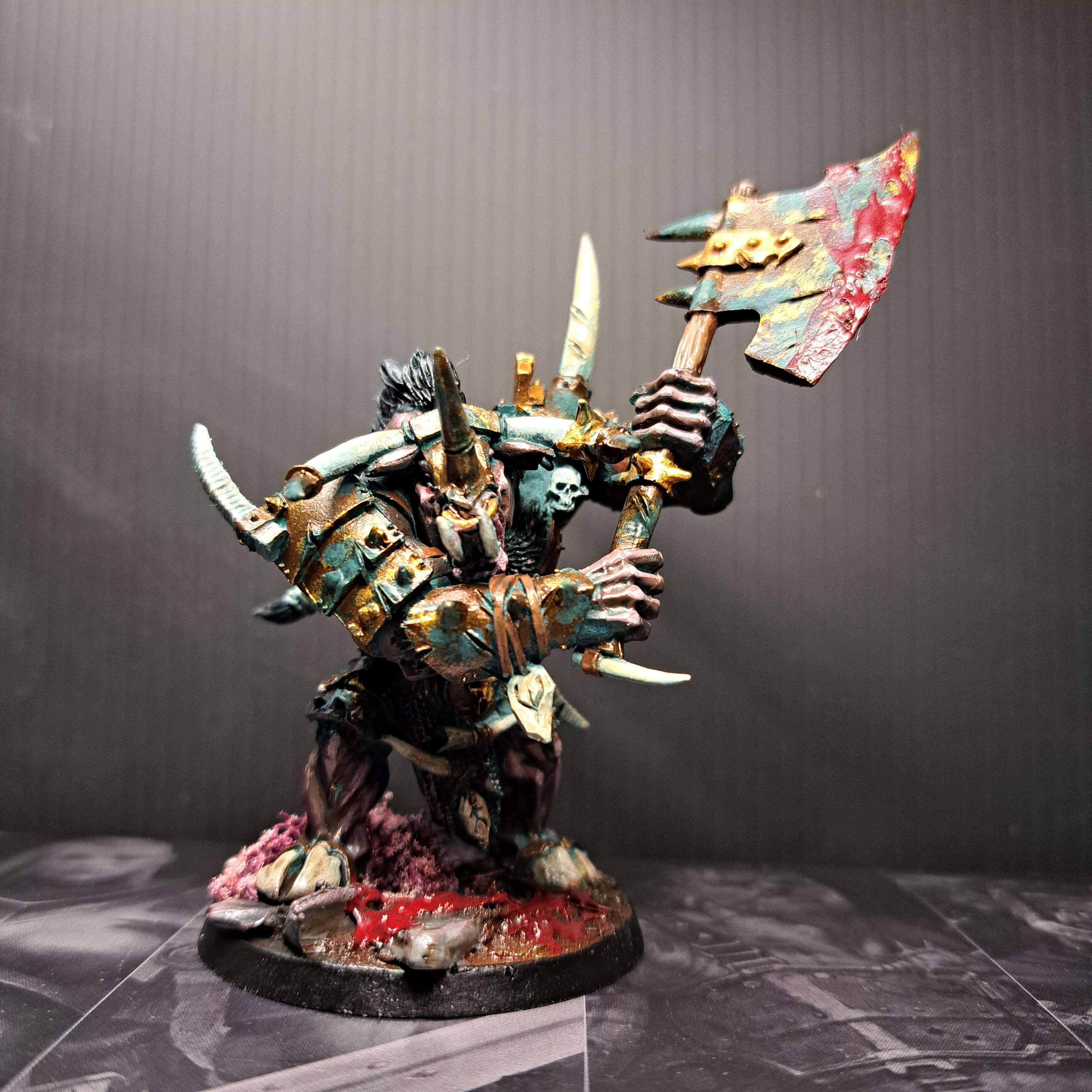 A doombull with worn oxidized copper armor and axe. Accents of gold metal. A dark brown skin. A red gorey base with jagged stones.
