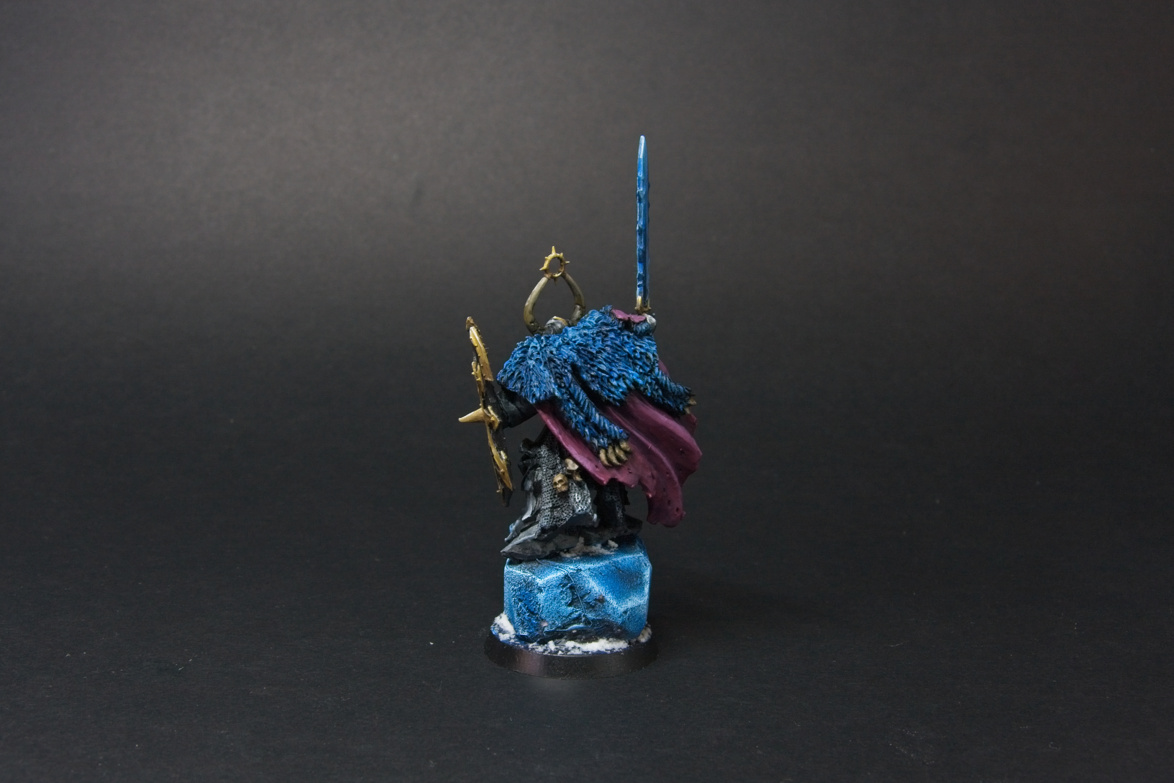 A blue bear pelt cape on his shoulders.