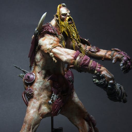 The gargant has a yellow-golden facial hair, braided and messy.