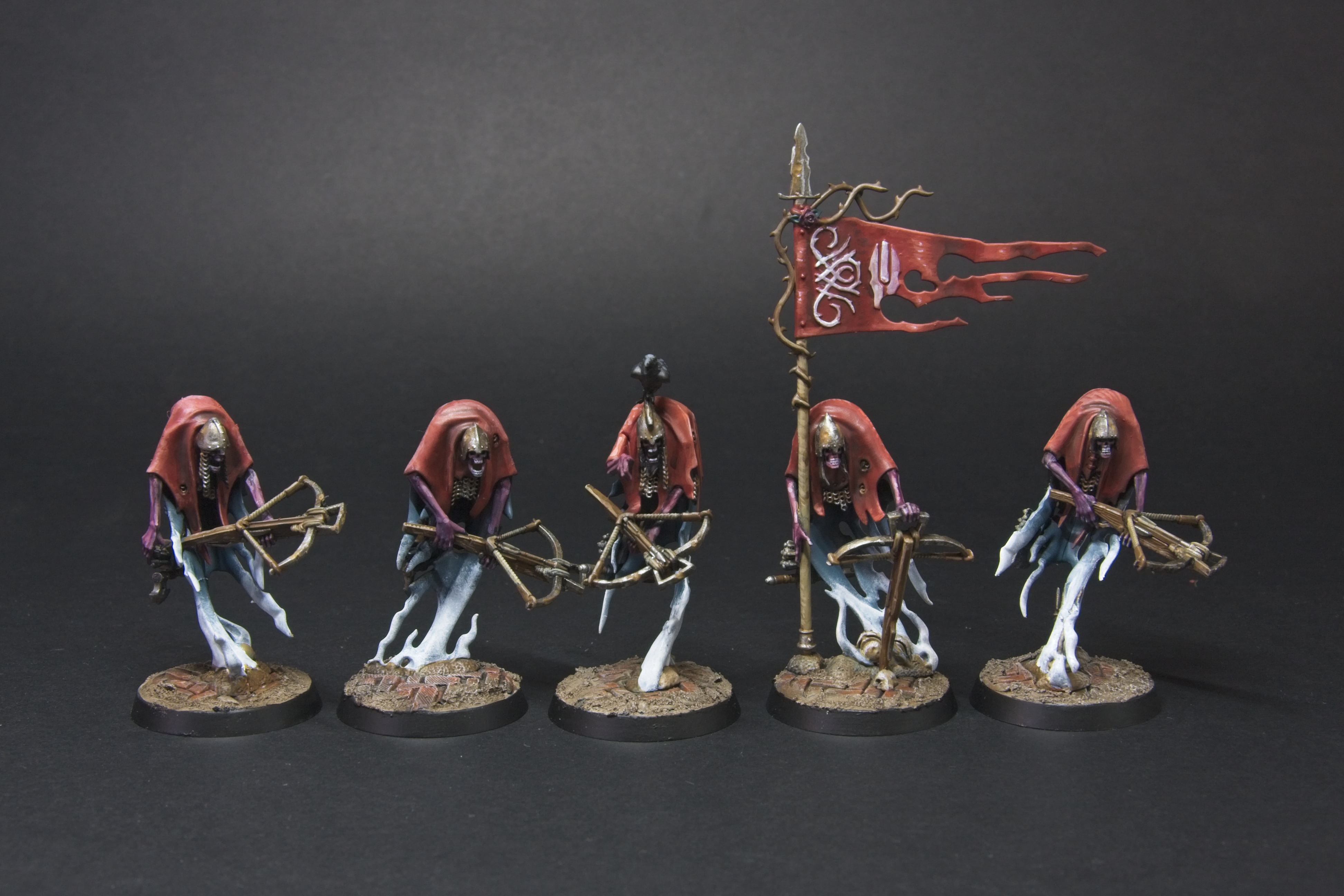Five spectral crossbow men, with red cloaks, rusty metallics, and a blue to white ghostly body.