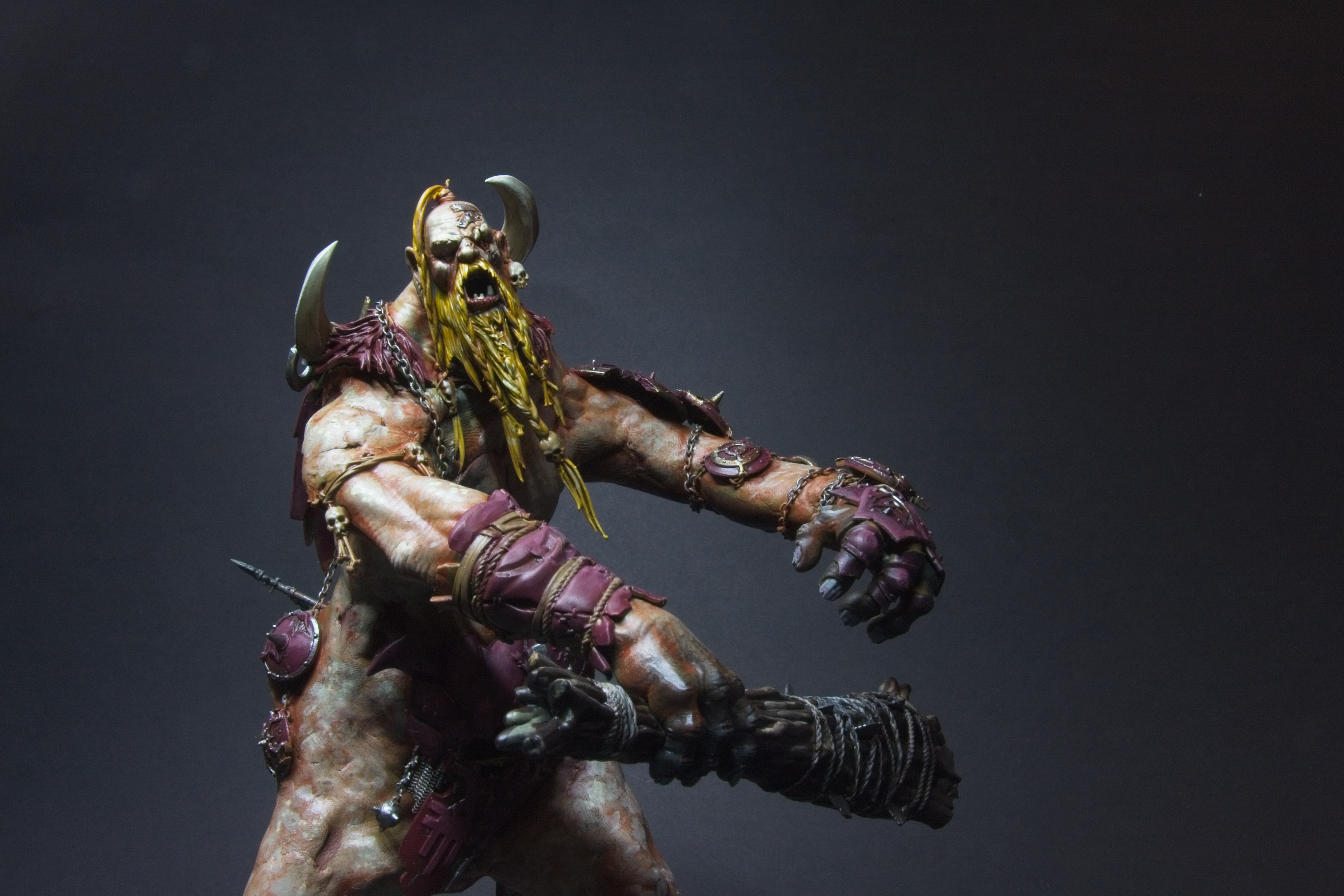 A mega-gargant, with pallid skin, purple clothes, and a yellow-gold beard.