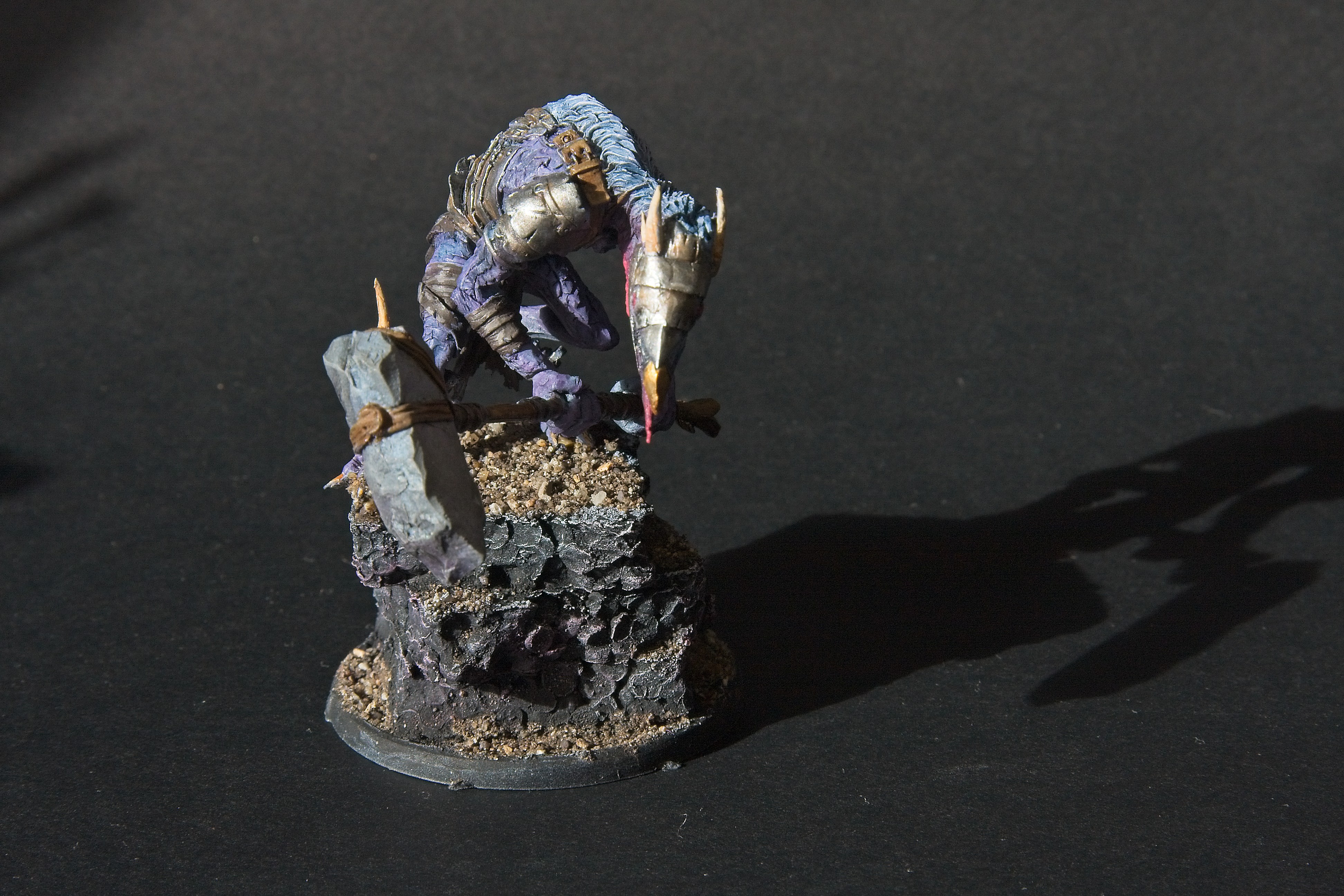 His hammer is a crude piece of stone strapped to a stick.