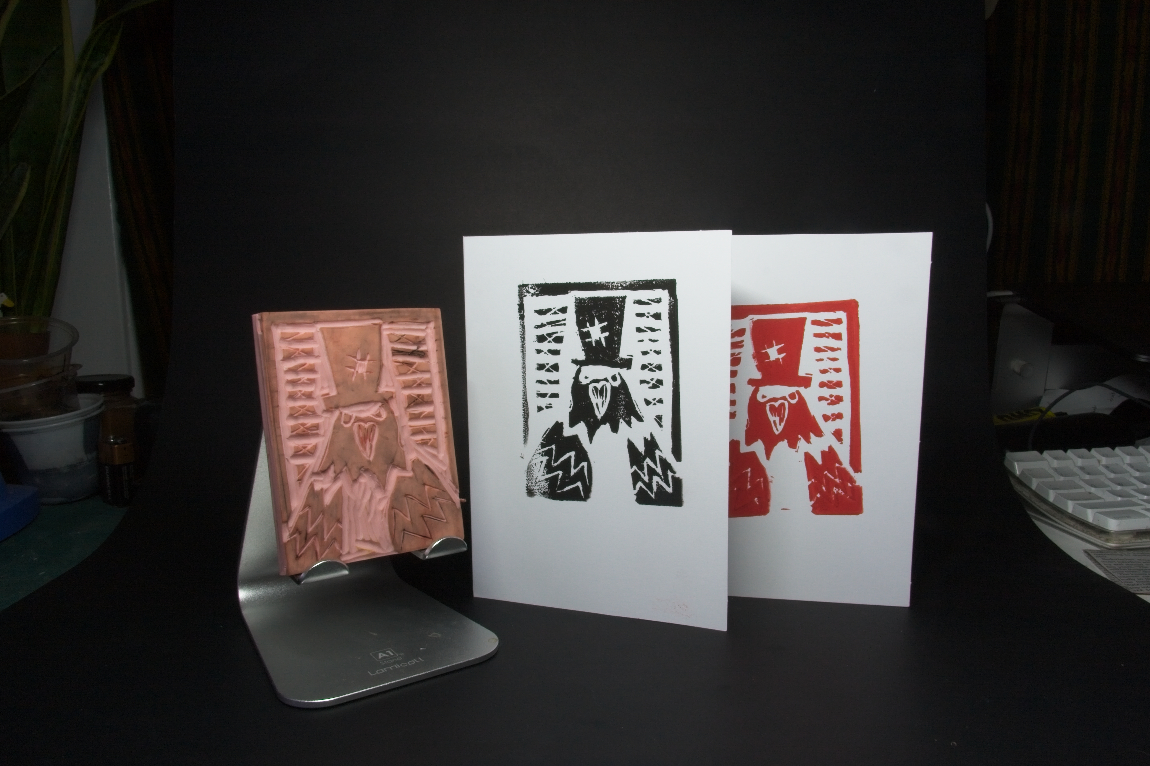 A pigeon with a tophat design, on both a lino carving and two cards